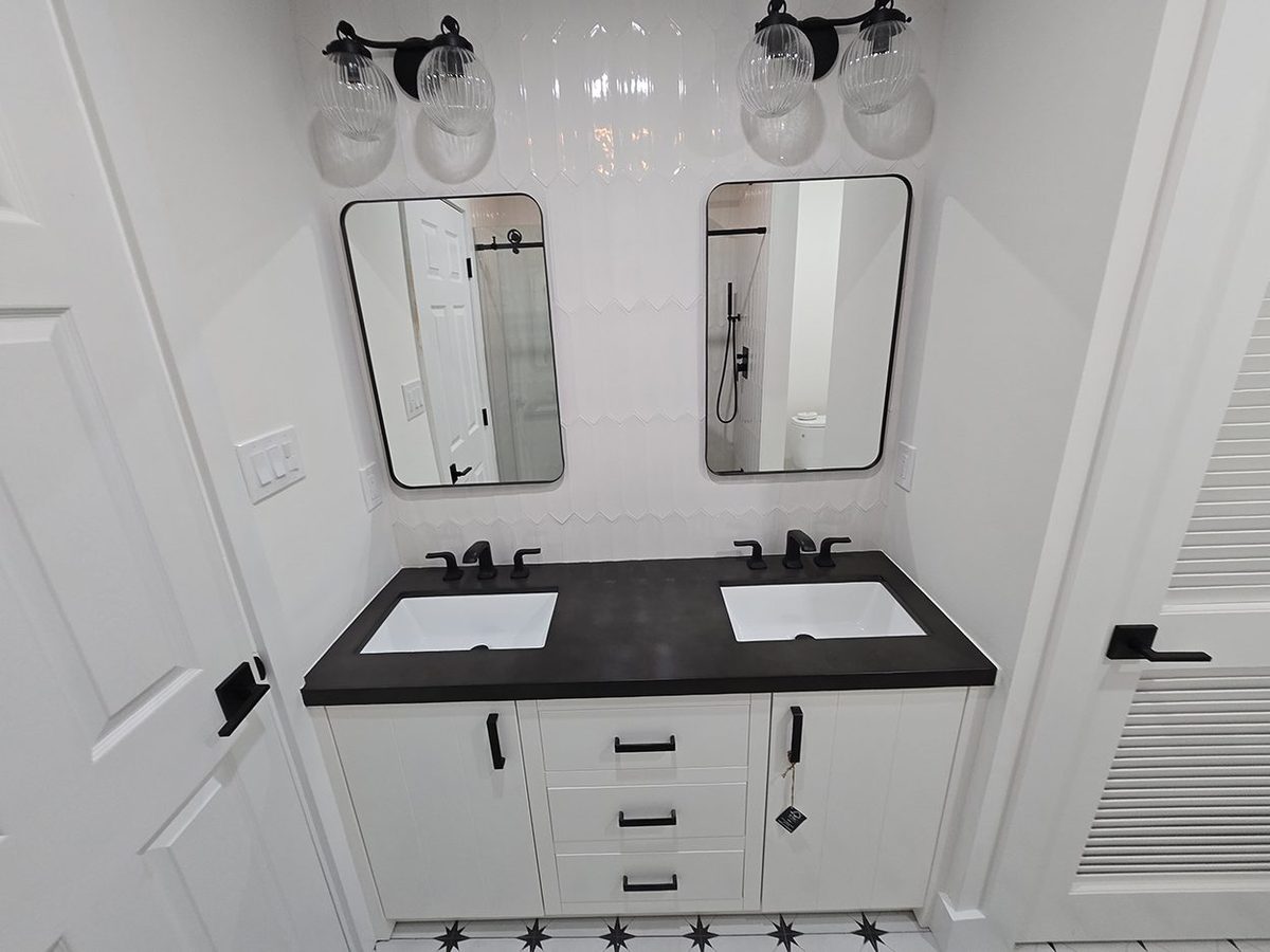 Remodeled bathroom by Grant Langston Customs with dark quartz double vanity and modern fixtures
