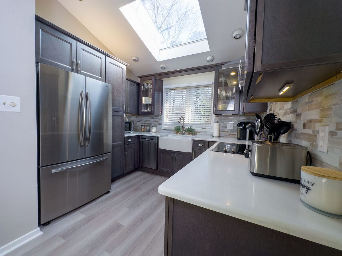 Modern remodeled kitchen by Grant Langston Customs with skylight, stainless appliances, and custom cabinetry